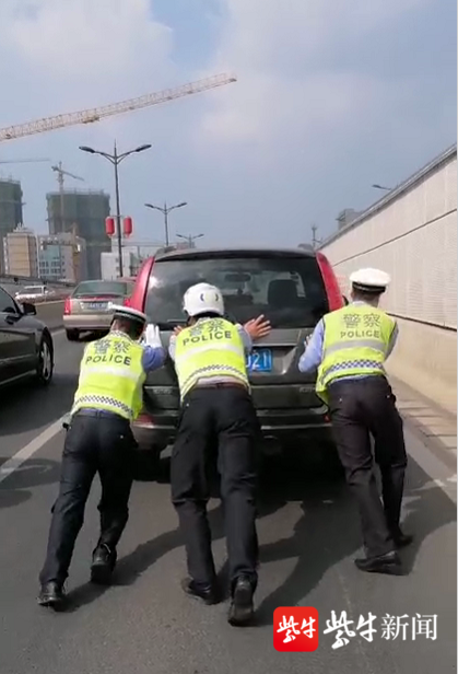 图为警方合力推走故障车.