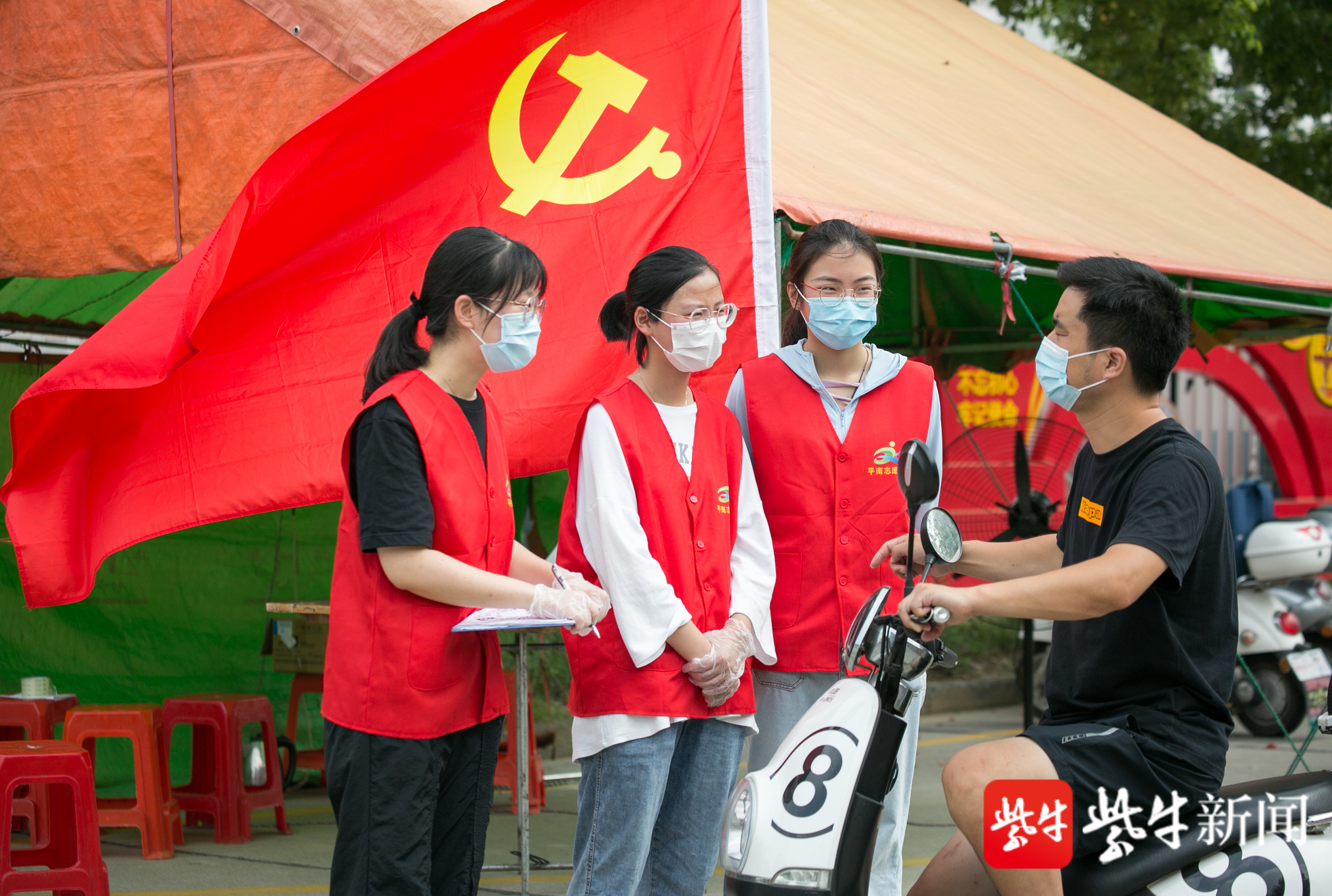 在江苏省如皋市长江镇平南社区一疫情防控卡口,大学生志愿者在了解