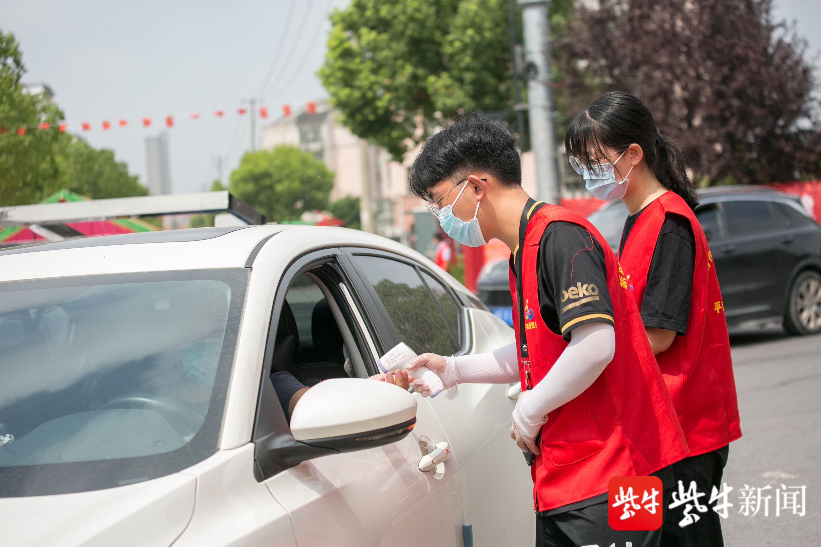 在江苏省如皋市长江镇平南社区一疫情防控卡口,大学生志愿者正在为