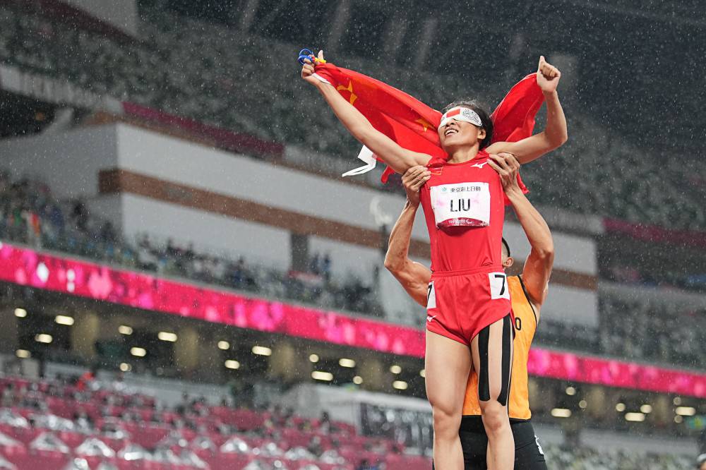 夺冠后,领跑员徐冬林举起了刘翠青