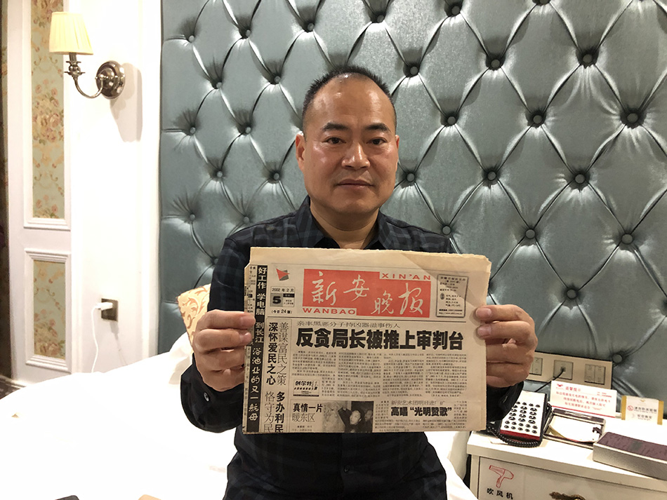 李金奎举着刊登着当年报道的报纸 本文图片 澎湃新闻记者 卫佳铭