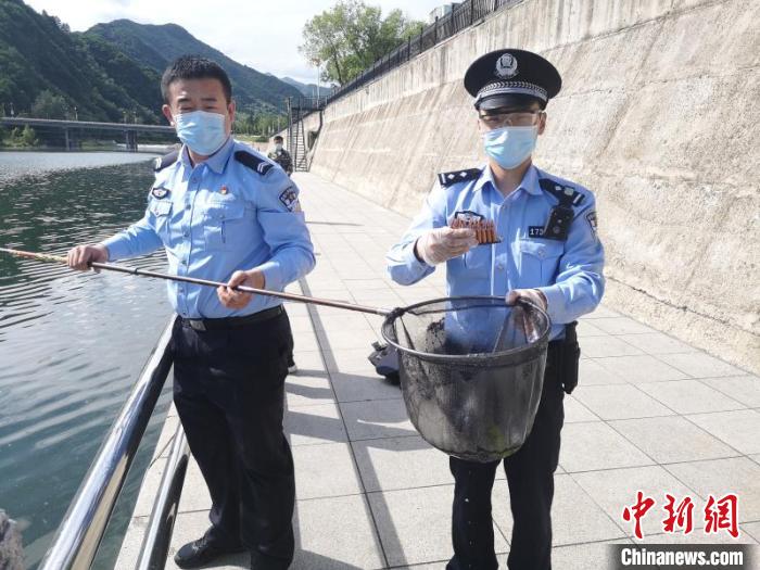 民警使用打捞工具在辖区内河水底打捞出130发步枪子弹.