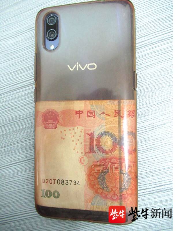 图为保护壳内放有100元纸币的手机.孝辉 摄