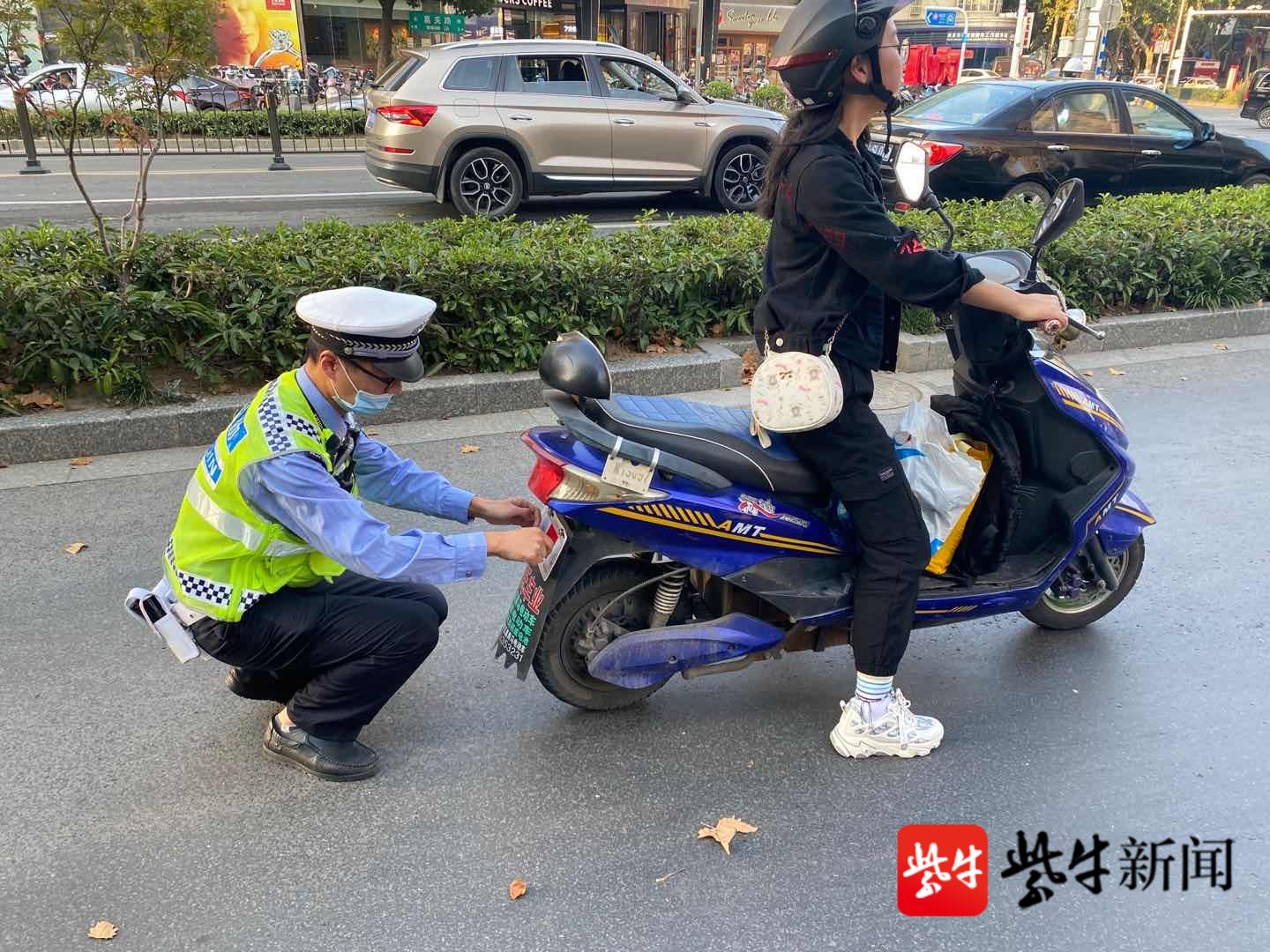 图为民警为市民电动车贴上反光贴