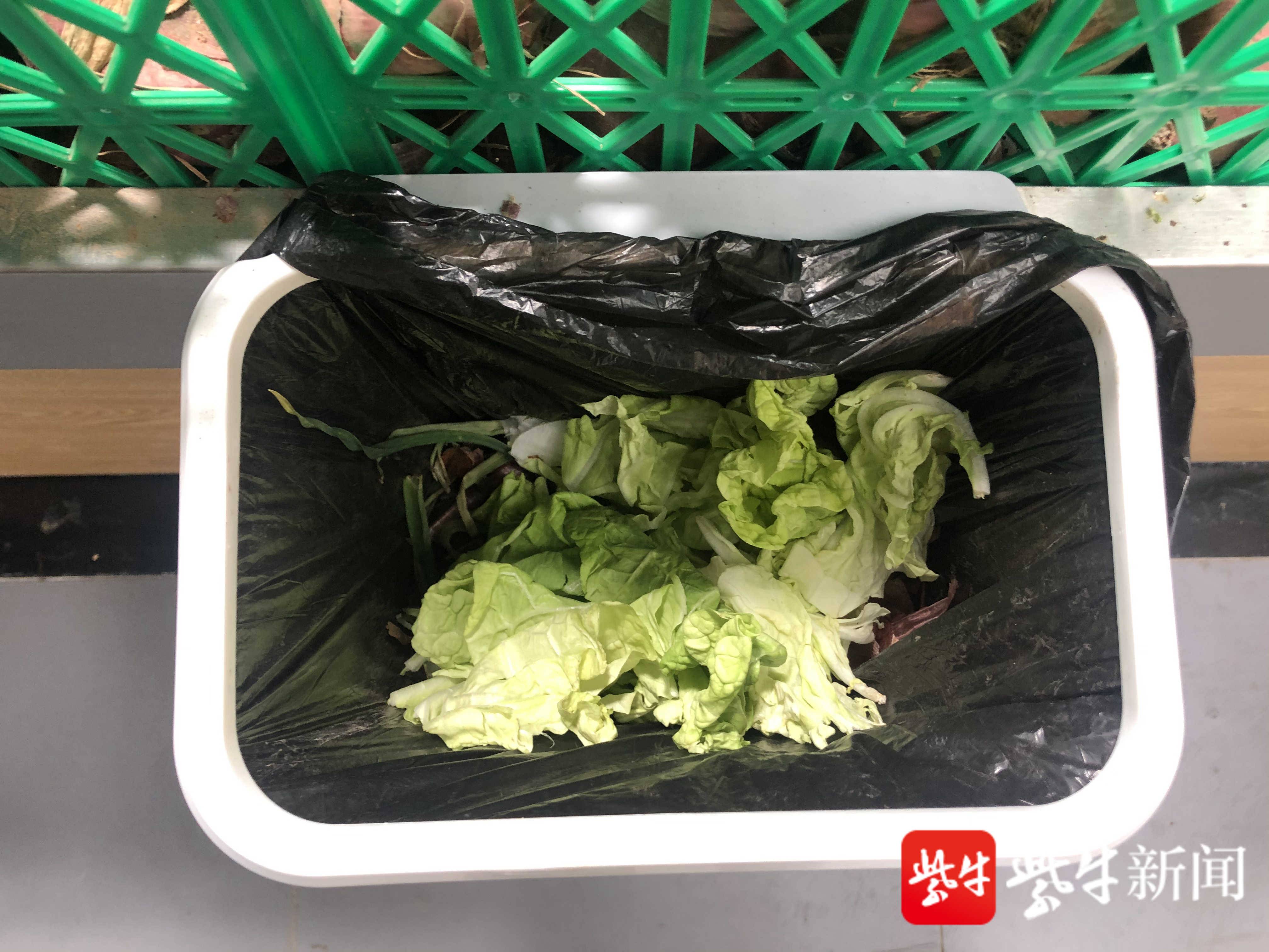 而摊位里则放置厨余垃圾,其他垃圾两分桶——前者是给顾客挑选菜品时