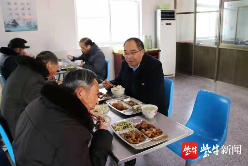 党委书记张恩海和老人边吃边聊