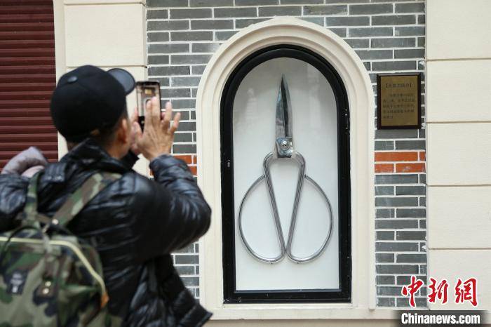 超大剪刀引来众多民众围观,不少游客比着剪刀手和大剪刀合影留念.