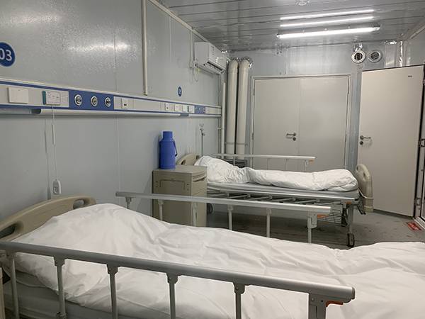 进门后先是缓冲间,缓冲间两侧是分别摆有两张病床的不同病房.