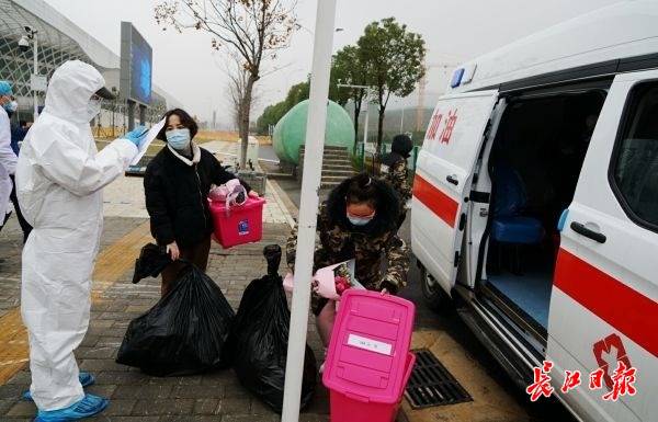 26日上午,从江夏大花山户外运动中心的方舱医院出院的患者准备乘车