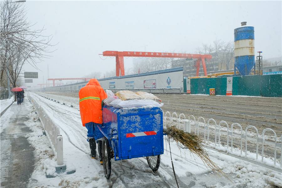 北京迎来大雪天气,环卫工人在通州玉桥中路清扫积雪.