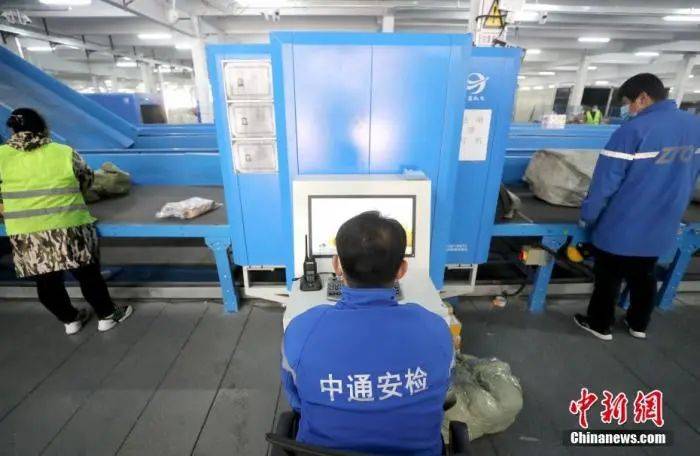 快递企业员工在对快递进行安检.中新社记者 张宇 摄