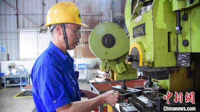 何海东操作冲床生产接线端子. 王以照 摄