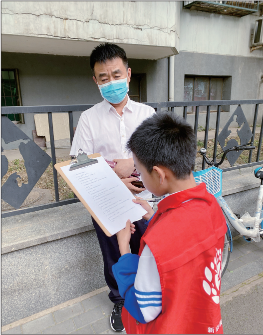 北京体育馆路小学陈奕涵同学在校门口请家长做未保法调查问卷