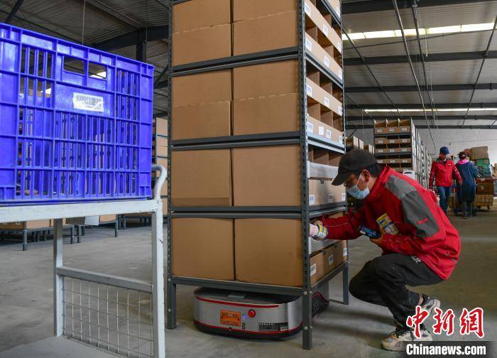 图为西藏自治区级公共物流仓储配送中心里,作业人员将把货物装上搬运